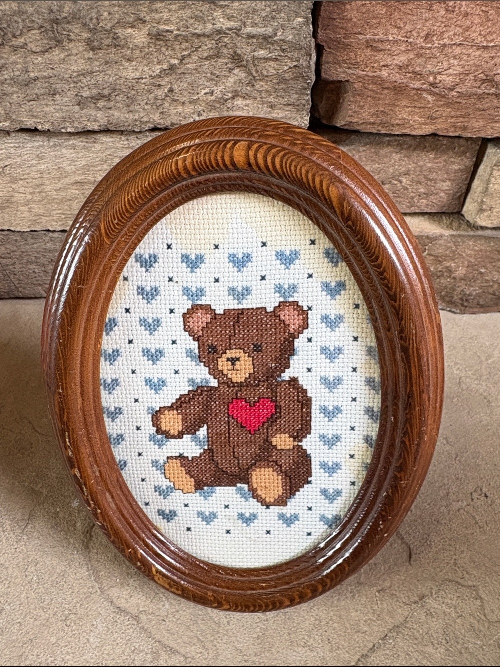 Vintage handmade cross stitch bear in oval wooden frame